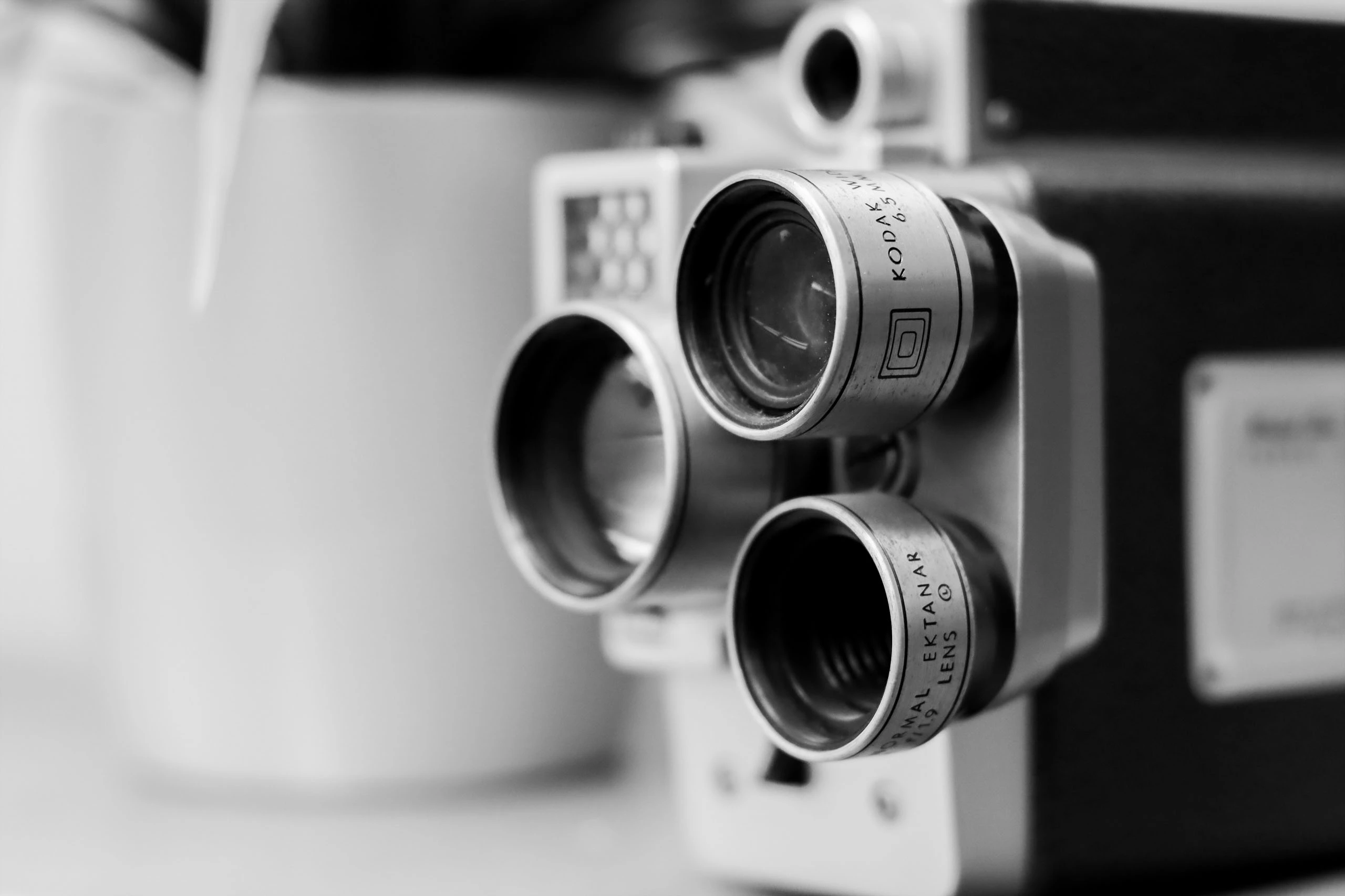 black and white image of a old school film camera that has three lenses